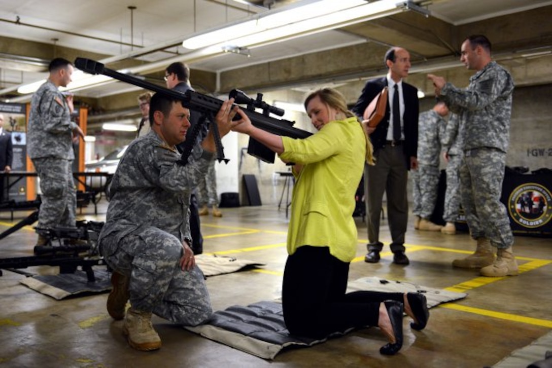Members of Congress and staffers got a first-hand chance to examine weapons and have one-on-one discussions with Soldiers during Army Day on Capitol Hill, April 25, 2013. Here, congressional staffer Sarah Rogers handles a weapon as Major Kralyn Thomas with the Army's Program Executive Office Soldier explains its capabilities.(U.S. Army photo by Lisa Ferdinando/Released)