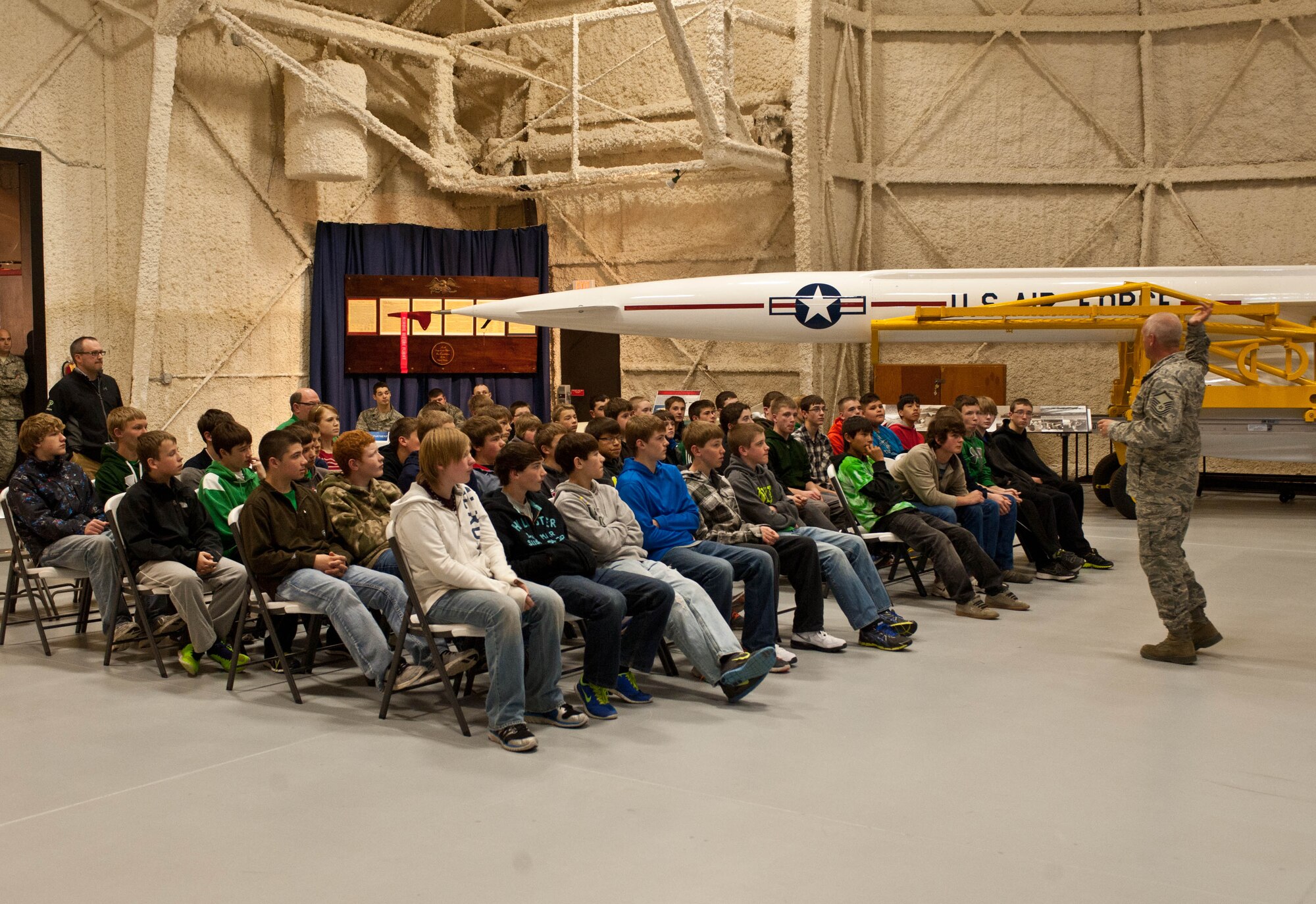 Master Sgt. Eric Grim, South Dakota Air and Space Museum curator, speaks to eighth-grade students from Pierre Middle School at the SDASM in Box Elder, S.D., April 23, 2013 during a career day field trip. Throughout the day, more than 200 students visited various locations including area businesses, upper level education facilities and the SDASM. (U.S. Air Force photo by Airman 1st Class Zachary Hada/Released)