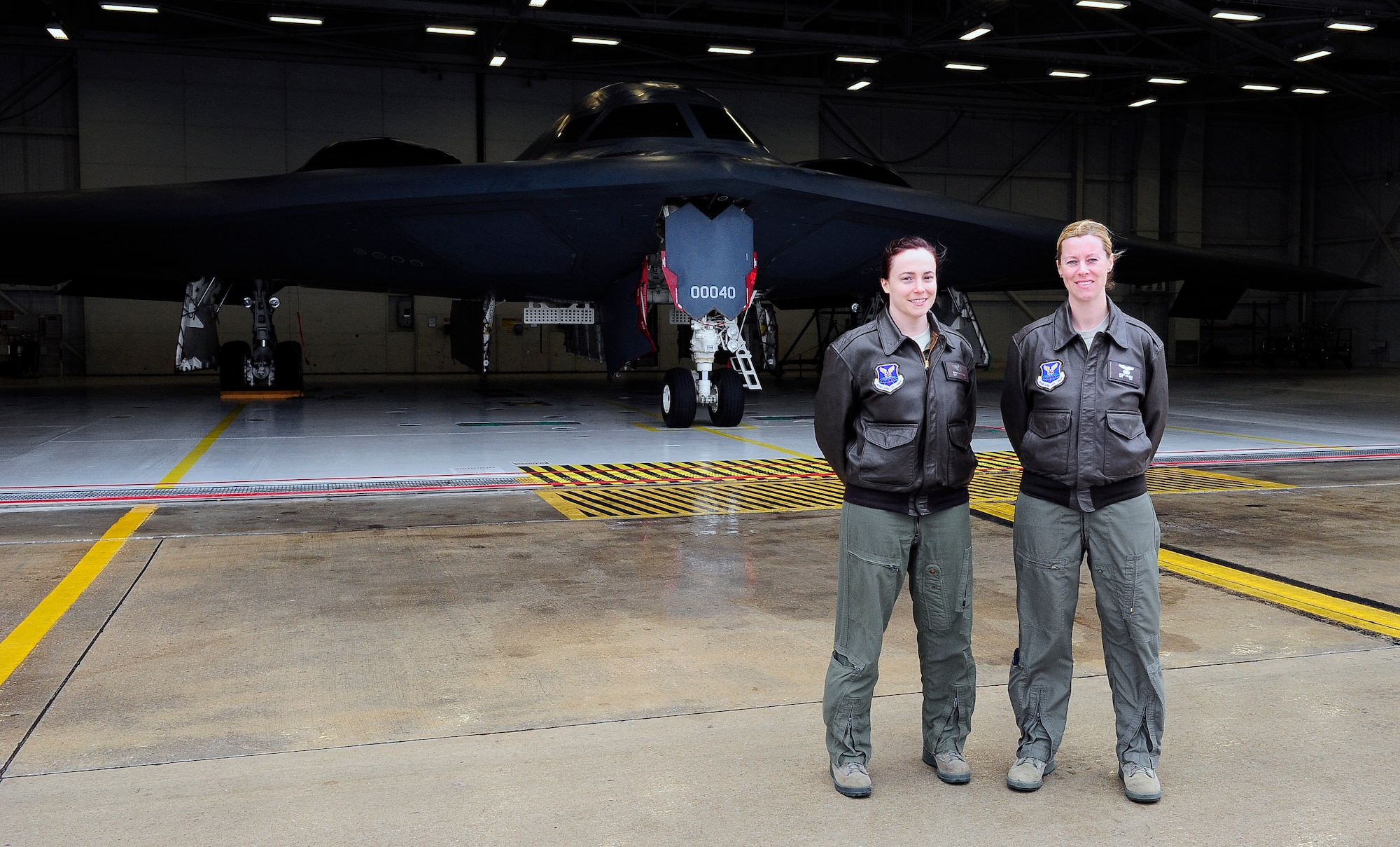 Captains Jennie Swiechowicz and Nicola Polidor, both 393rd Bomb Squadron B-2 Spirit pilots, stand outside a B-2 hangar at Whiteman AFB, Mo., April 23, 2013. Polidor and Swiechowicz are the sixth and seventh women ever to fly to the B-2. (U.S. Air Force photo by Airman 1st Class Shelby R. Orozco/Released)