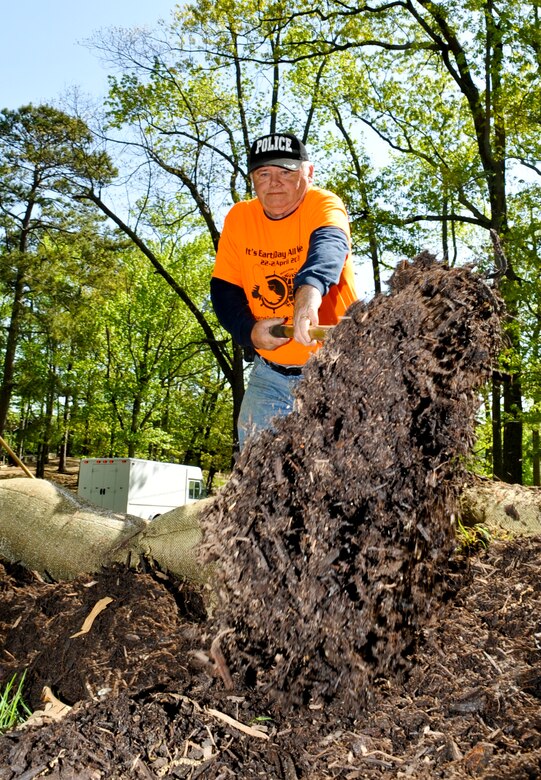 Douglas Bateman, 733rd Civil Engineer Division construction inspector, shovels mulch at the Warwick Pier historical site during Earth Week events at Fort Eustis, Va., April 26, 2013. Volunteers spread mulch in an effort to reconstitute soil lost by erosion over time. (U.S. Air Force photo by Staff Sgt. Wesley Farnsworth/Released)