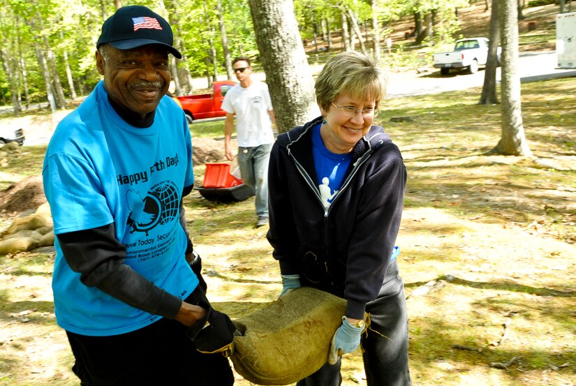 Earth Week volunteers Bill Barnes and Julie Smith carry a sandbag to position it at a historical site during Earth Week events at Fort Eustis, Va., April 26, 2013. The sandbags will be used to help preserve an American Civil War confederate firing position that has been eroding away through the years. (U.S. Air Force photo by Staff Sgt. Wesley Farnsworth/Released)