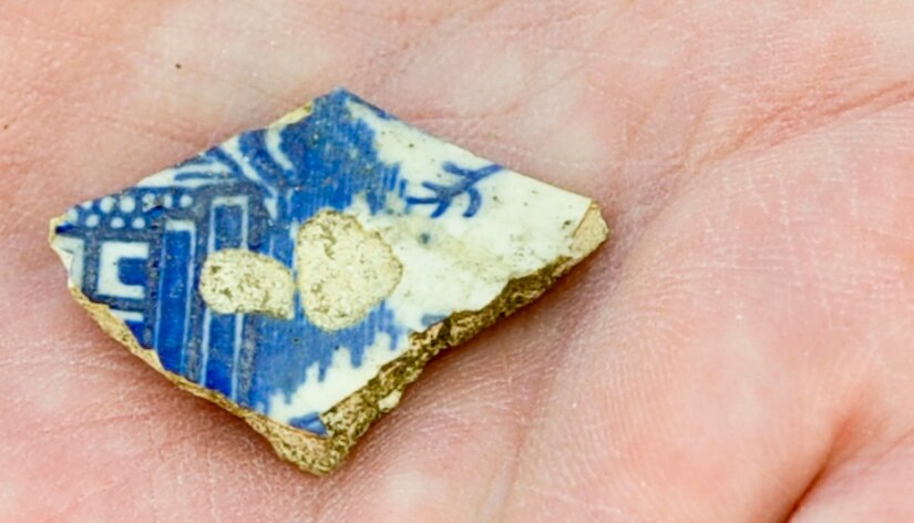 A volunteer displays a piece of ceramic, presumed to be from the late 18th or early 19th century, found at the Warwick Pier historical site during Earth Week events at Fort Eustis, Va., April 26, 2013. More than 230 volunteers joined environmental protection officials at Langley Air Force Base and Fort Eustis in a series of clean-up and educational projects on each installation. (U.S. Air Force photo by Staff Sgt. Wesley Farnsworth/Released)