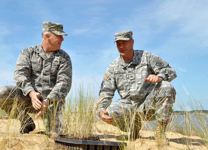 (From left) U.S. Air Force Col. John J. Allen Jr., 633rd Air Base Wing commander, and U.S. Army Col. Thomas Wetherington, 733rd Mission Support Group commander, plant salt meadow cordgrass along the James River as part of Earth Week at Fort Eustis, Va., April 25, 2013. The celebration of Earth Day began in 1970, when U.S. Senator Gaylord Nelson of Wisconsin introduced the idea for a “national teach-in on the environment,” eventually building a national staff to support his vision nationwide. (U.S. Air Force photo by Staff Sgt. Wesley Farnsworth/Released)