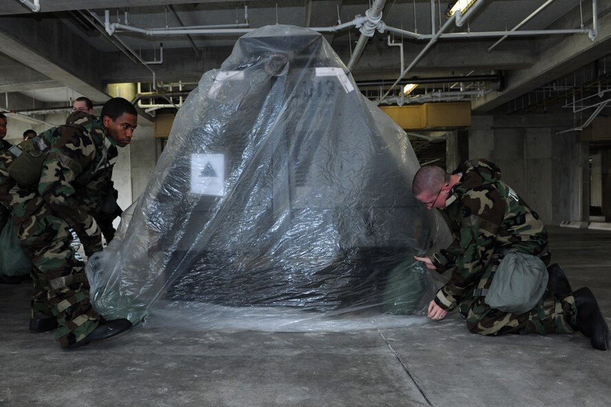 18th Mission Support Group personnel wrap a generator during an Ability to Survive and Operate Rodeo on Kadena Air Base, Japan, April 25, 2013. At the ATSO Rodeo, a training exercise event, Airmen wrapped a government asset in a simulated chemical environment to keep the asset from becoming contaminated. (U.S. Air Force photo by Airman 1st Class Hailey R. Davis/Released)