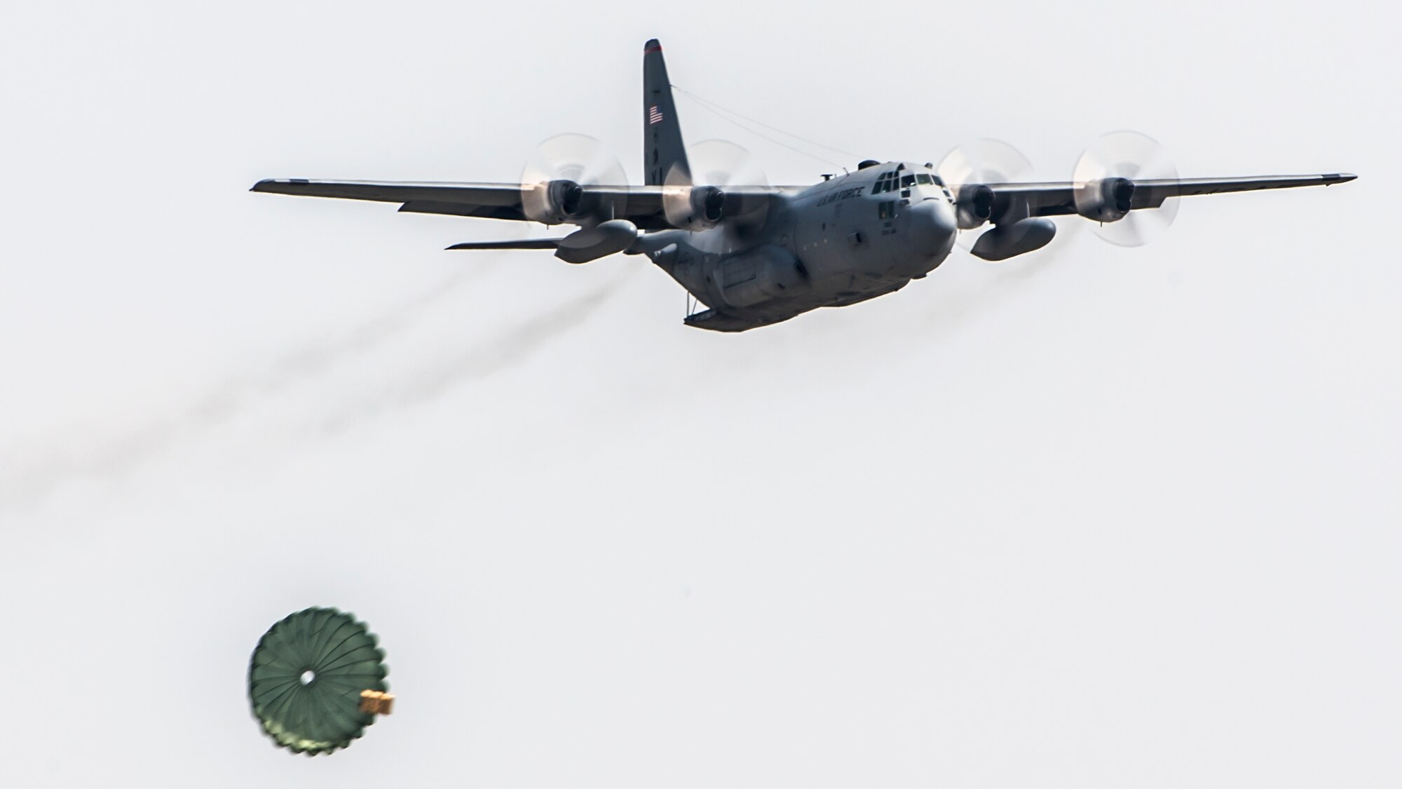 A U.S. Air Force C-130 Hercules performs a practice airdrop over Yokota Air Base, Japan, April 18, 2013. Yokota aircrews keep their skills sharp by conducting realistic airdrop training at the base airfield. (U.S. Air Force photo by Captain Raymond Geoffroy) 