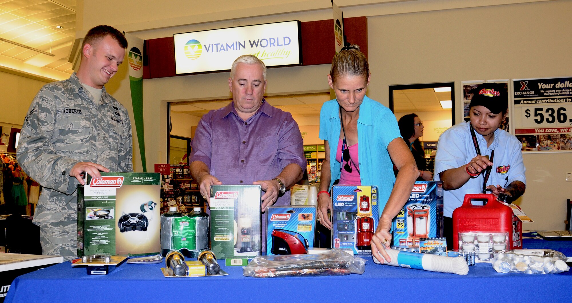 Airman 1st Class Keifer Roberts, 36th Civil Engineer Squadron emergency management plans and operations journeyman, along with Army and Air Force Exchange Service employees, demonstrate assembling a typhoon preparation kit at the AAFES on Andersen Air Force Base, Guam, April 24, 2013. The purpose of the demonstration was to educate the base populous on how to prepare for the upcoming typhoon season. (U.S. Air Force photo by Airman 1st Class Mariah Haddenham/Released)  