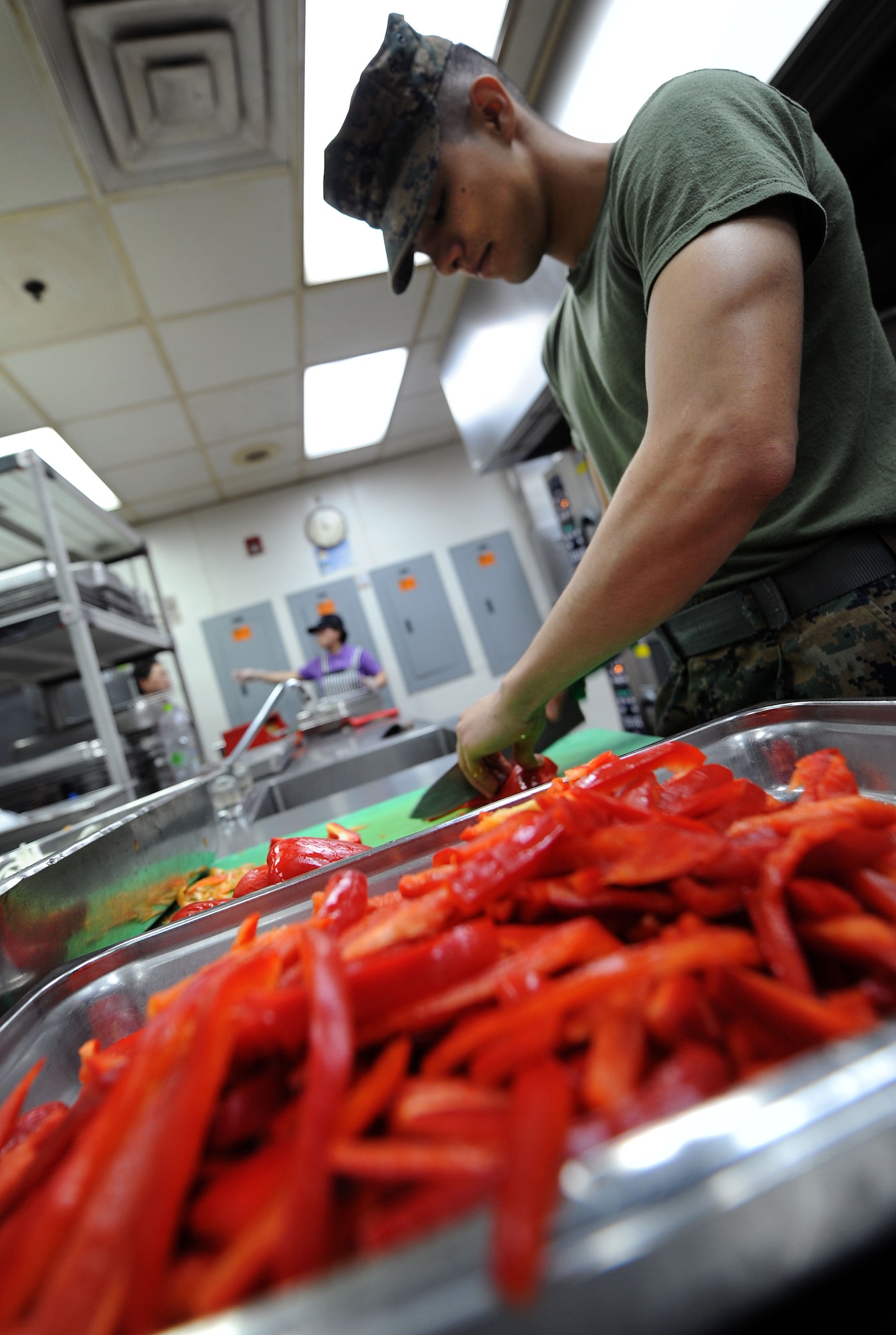 Cpl. Alan Peterson, Marine Wing Squadron Support 171 food service specialist, slices red peppers in preparation for dinner at the Ginko Tree dining facility at Osan Air Base, Republic of Korea April 23, 2013. Shift workers at the DFAC prepare the different meals, work the grill, temperature check food and make sure the facility remains clean as a part of their job every day. (U.S. Air Force photo/Staff Sgt. Sara Csurilla)
