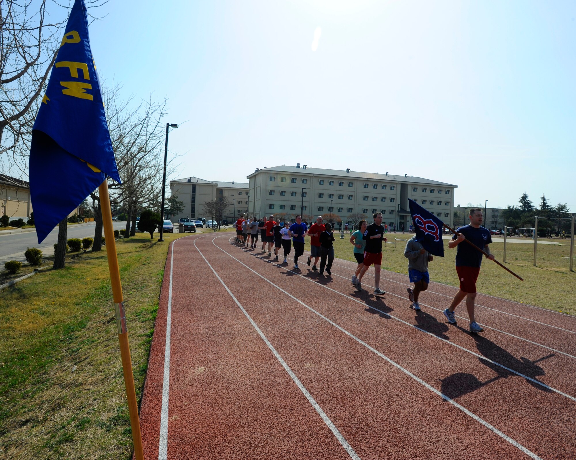 KUNSAN AIR BASE, Republic of Korea – More than 90, 8th Operations Support Squadron members run laps to show support for Boston Marathon bombing victims, during a tribute run, April 19, 2013, at the base track. The 8th OSS Members ran with the Boston Red Sox ‘Boston Strong’ flag to honor the victims of the attacks at the 117th Boston Marathon, Boston, Mass., April 15, 2013. (U.S. Air Force photo by Staff Sgt. Tong Duong)
