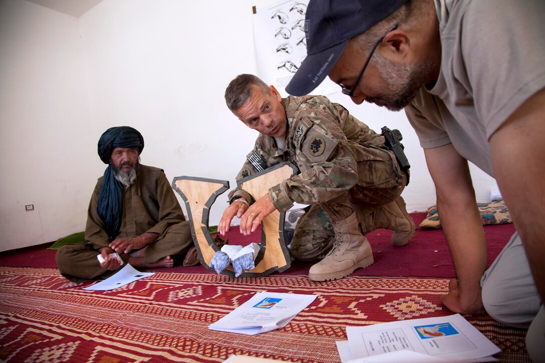 U.S. Army Maj. Eugene Johnson, center, explains the normal birthing process for livestock to staff members of the Directorate of Agricultural, Irrigation and Livestock in Kajaki in Helmand province, Afghanistan, April 24, 2013. Johnson, a veterinarian, is assigned to the Georgia Agricultural Development Team 3, Regimental Combat Team 7.