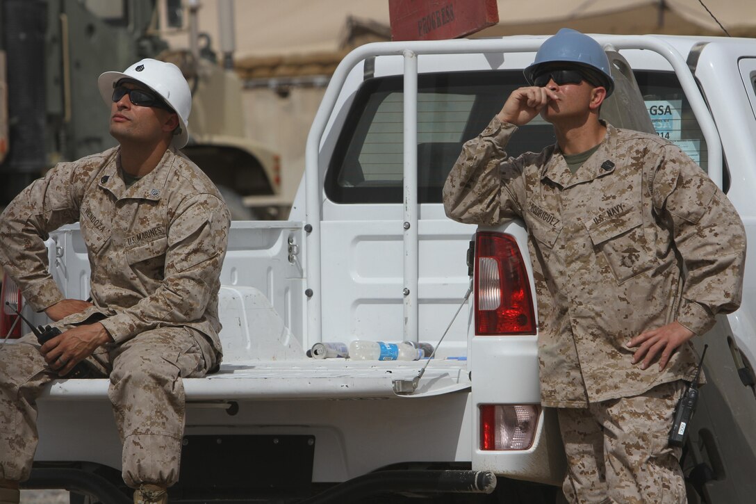 Staff Sgt. Osman Mendoza, the 8th Communications Battalion transmission chief, left and Petty Officer 2nd Class David Rodriguez, the battalion's corpsman, keep an eye on battalion's Marines fixing equipment the communications tower. 