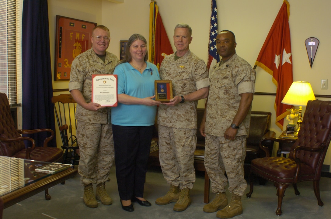 From left: Col. George M. Dallas, Carol Wilander, Lt. Gen. James Amos and Sgt. Maj. James Futrell display the award and citation that was presented to the general’s secretary for her dedication to the Marine Corps Combat Development Command on May 29, 2008.