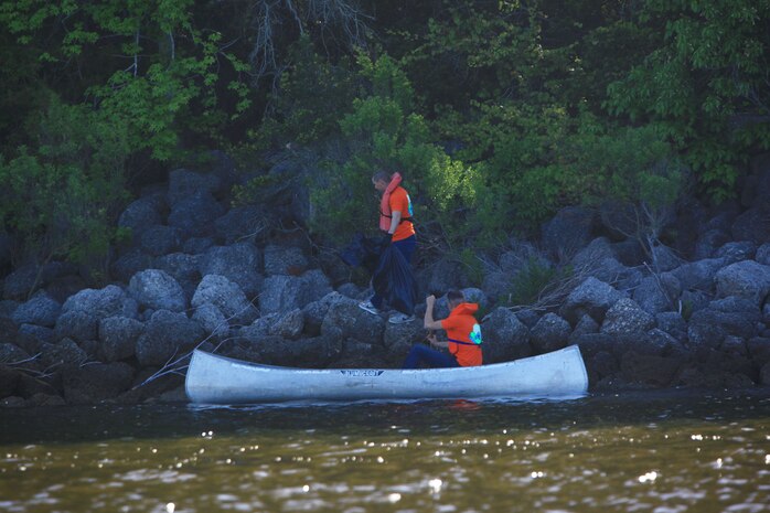 Two volunteers canoe and walk around the coastline of Camp Lejeune, N.C., April 26, 2013 during the Splash for Trash cleanup. Participants were equipped with first aid kits, sunscreen, lunch and water. (U.S. Marine Corps photo by Lance Cpl. Shawn Valosin)