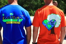 Two volunteers for the Splash for Trash event show off their Earth Day t-shirts, which were designed by Brewster Middle School and Lejeune High School. These shirts were given to volunteers to make them easily identifiable while they were out on the waterways around Camp Lejeune, N.C., April 26, 2013.  (U.S. Marine Corps photo by Lance Cpl. Shawn Valosin)
