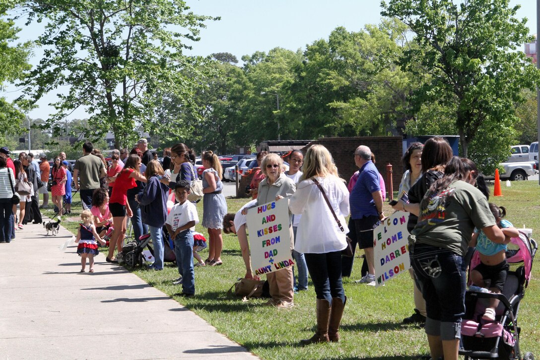 Friends and family members gather around the sidewalk in front of 2nd Combat Engineer Battalion’s headquarters building waiting for buses to pull up, April 26, 2013, aboard Camp Lejeune, N.C. They are waiting for their loved ones with 2nd CEB to return home from a seven month deployment to Helmand Province, Afghanistan.

