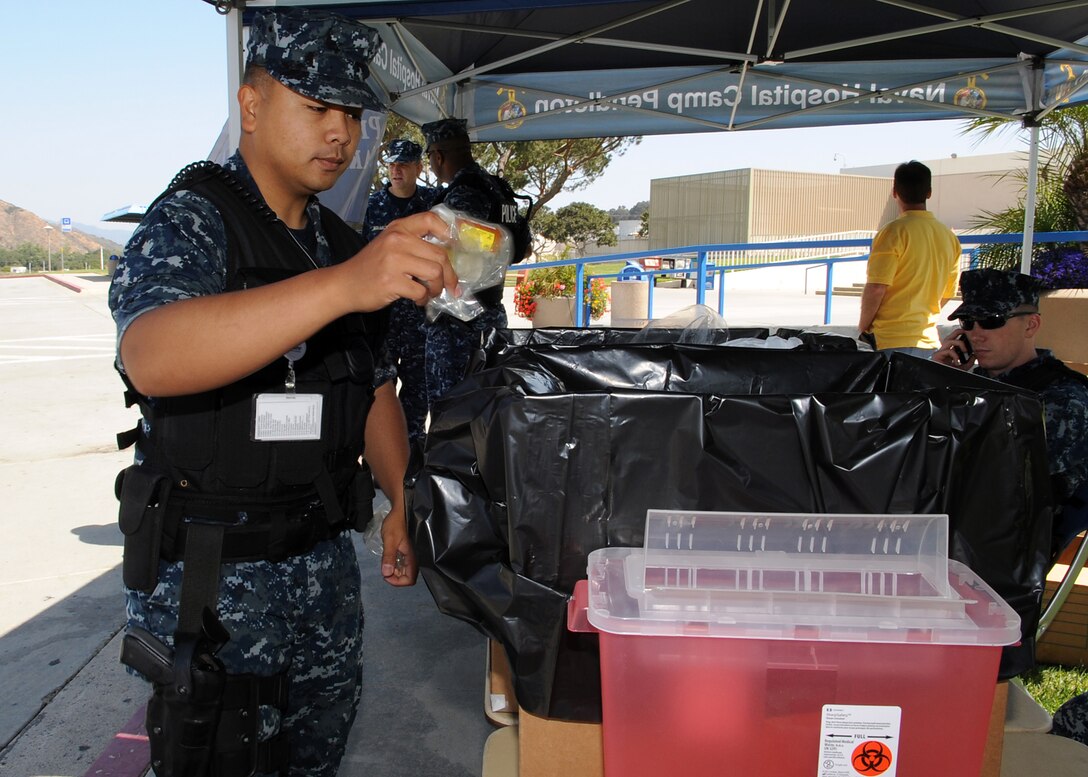 Seaman Danie Dancel, a patrolman with the Naval Hospital Camp Pendleton Security Department discards unused, unwanted medications during the Drug Enforcement Administration’s National Prescription Drug Take Back Day April 27.  The national event is to help prevent medication misuse, abuse, and theft.  (U.S. Navy photo by Mass Communication Specialist 1st Class Michael R. McCormick)