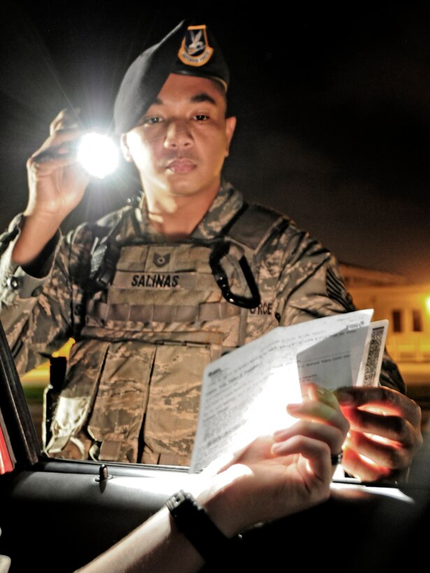 Tech. Sgt. Wilfredo Salinas, 36th Security Forces Squadron Law Enforcement and Security delta flight sergeant, checks a driver’s license and vehicle registration during a traffic stop on Andersen Air Force Base, Guam, April 22, 2013. The 36th SFS Law Enforcement and Security flight sergeant’s mission is to ensure the protection of Andersen AFB’s residents and resources. (U.S. Air Force photo by Airman 1st Class Marianique Santos/Released)