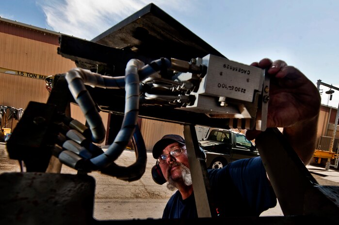 Thomas Jaynes, a Computer Science Corporation Aerospace Ground Equipment worker, checks a munitions loader for hydraulic leaks April 25, 2013, at Nellis Air Force Base, Nev. The AGE workers directly support the operations of the flying operations for the 57th Wing. (U.S. Air Force photo by Senior Airman Daniel Hughes)