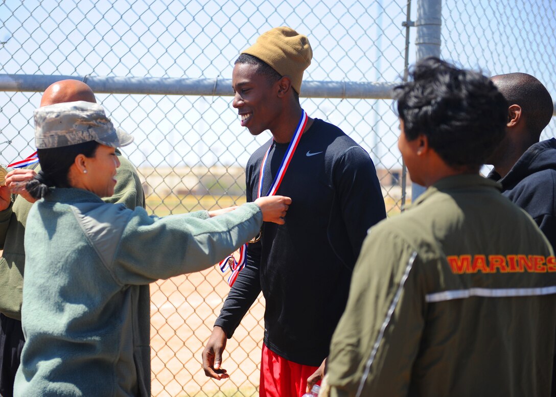 U.S. Air Force Lt. Col. Naomi Welcome, 7th Force Support Squadron commander, awards a member of the winning team with a first place medal after a kickball tournament April 24, 2013, at Dyess Air Force Base, Texas. The Dyess Marine Corps Reserve Detachment 1 won the championship game against the 7th Munitions Squadron. (U.S. Air Force photo by Senior Airman Cierra Presentado/Released)