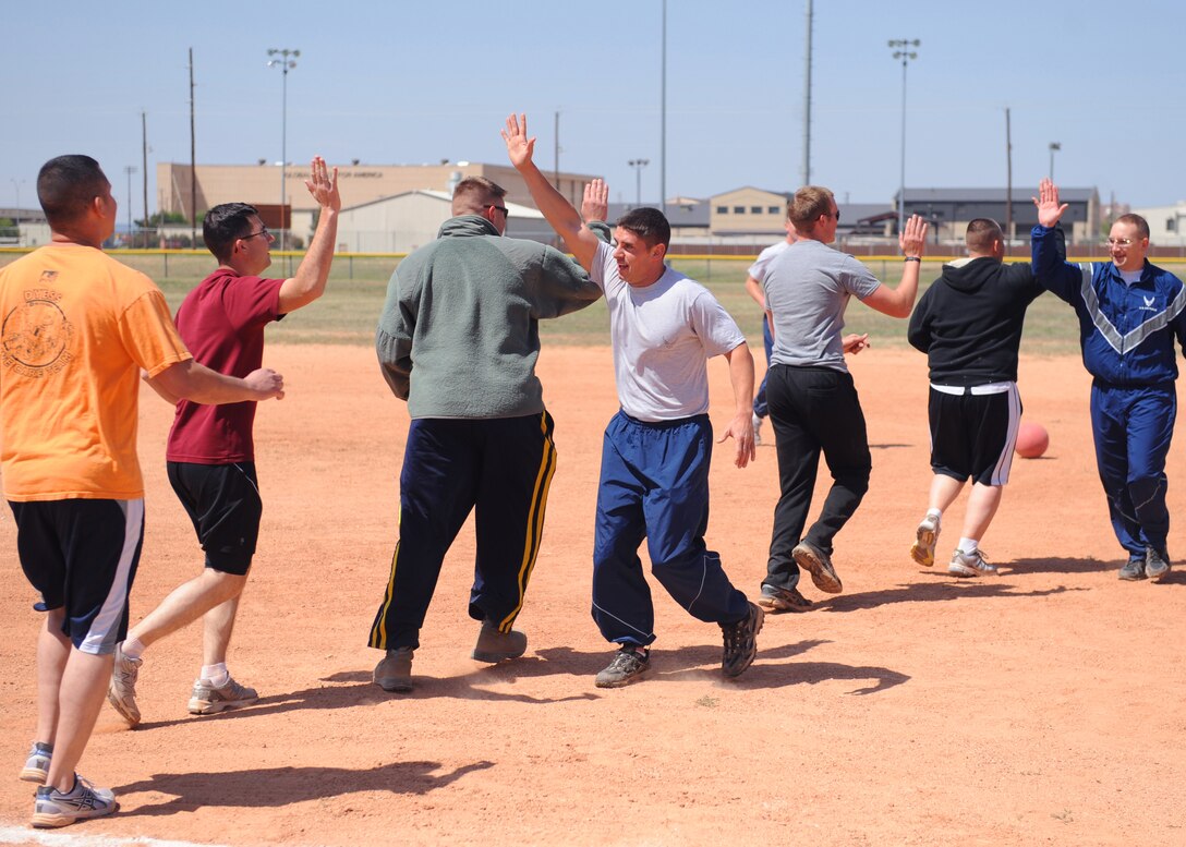 Dyess Marine Corps Detachment 1 and the 7th Munitions Squadron kickball teams congratulate each other after the Marines won the tournament April 24, 2013, at Dyess Air Force Base, Texas. Prizes were awarded to the top two scoring teams. (U.S. Air Force photo by Senior Airman Cierra Presentado/Released)