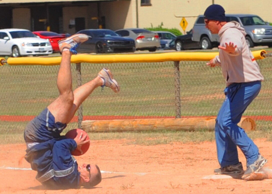 U.S. Air Force Master Sgt. Mike Grawe, 7th Force Support Squadron first sergeant, catches the ball as his opponent touches second base during a kickball tournament April 24, 2013, at Dyess Air Force Base, Texas. During the first game of the tournament, Marine Corps Reserve Detachment 1 outscored the Dyess first sergeants, allowing them to move to the next round. (U.S. Air Force photo by Senior Airman Cierra Presentado/Released)