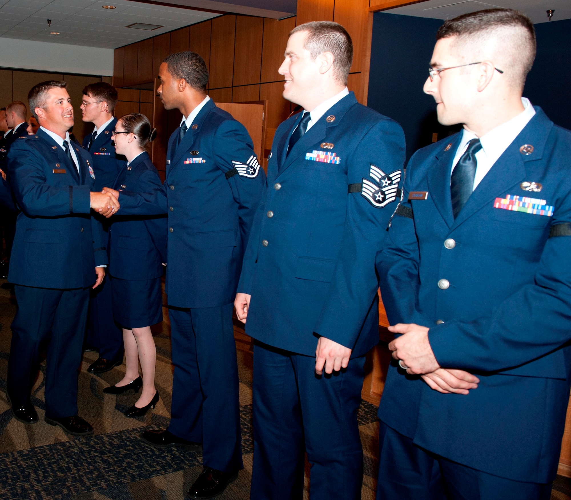 Col. David Graff, 325th Fighter Wing commander, shakes the hands of the May promotees during a ceremony at Horizons Community Activity Center April 30. (U.S. Air Force photo by Lisa Norman)
