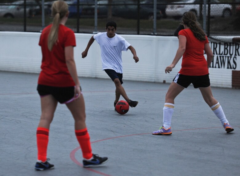 1st Lt. Jennifer Brown (left), and Shana Cumberworth (right), both soccer players for Team Red, intercept a member of Special Tactics Training Squadron Team during a soccer game at the Riptide Fitness Center’s hockey arena on Hurlburt Field, Fla, April 12, 2013. . (U.S. Air Force photo by Senior Airman Kentavist P. Brackin) 
