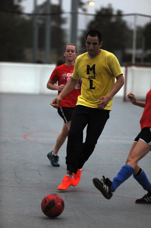 Airman Basic Mario Prince, soccer player for the Special Tactics Training Squadron Team, attempts to weave through players from Team Red during an arena soccer game at the Riptide Fitness Center’s hockey arena on Hurlburt Field, Fla., April 12, 2013. (U.S. Air Force photo by Senior Airman Kentavist P. Brackin)