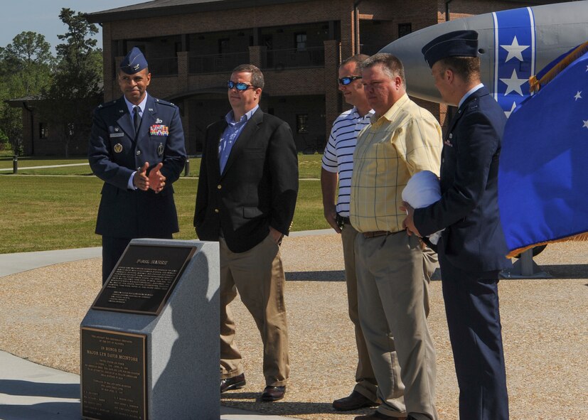 U.S. Air Force Col. Edward Ford, 23d Mission Support Group commander, and 1st Lt. Derek Dillard, 23d Logistics Readiness Squadron, accompany the sons of Maj. Lyn McIntosh, a rescue pilot killed during Operation Eagle  Claw in 1980, to unveil the name stencil on the F-86L Sabre and plaque dedicated to their father at Moody Air Force Base, Ga., April 27, 2013. The F-86 was a well-known landmark in Valdosta, Ga., for more than 40 years. It was relocated to Moody AFB April 25, 2012, to be refurbished and placed at the President George W. Bush Air Park at Moody Field. (U.S. Air Force photo by Senior Airman Eileen Meier/Released)