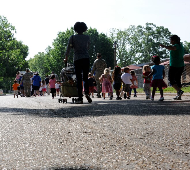 Parents, Child Development Center staff, and children walk during the Month of the Military Child Parade on Barksdale Air Force Base, La., April 30, 2013. Each year during the month of April, the Child Development Center here holds various events to celebrate military children, such as tree planting, a trike-a-thon, an art auction, a parent breakfast and parade. (U.S. Air Force photo/Airman 1st Class Andrew Moua)