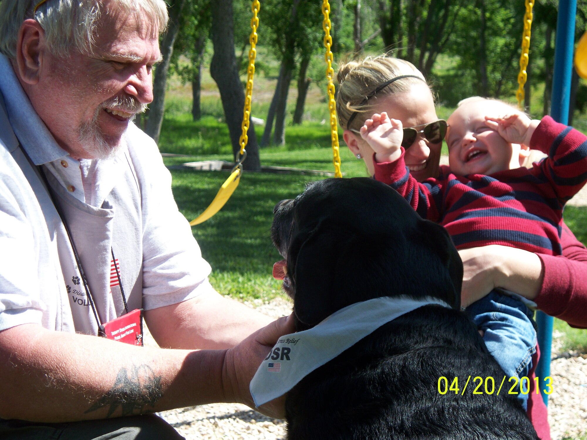 Smokey and her handler, Lee Boedeker, work with a family in the aftermath of the West Texas disaster. Smokey helped victims cope with their loss in the wake of the aftermath. (U.S. Air Force courtesy photo) 