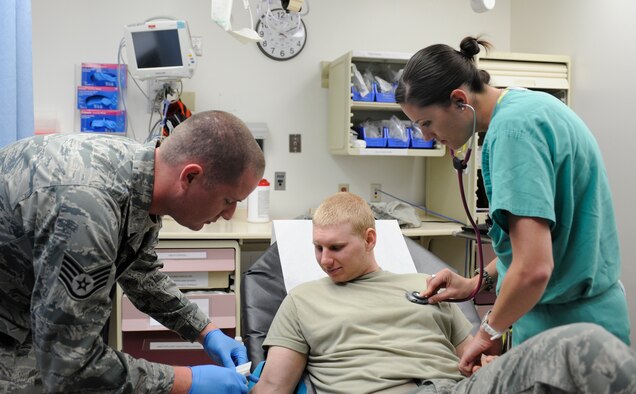 U.S. Air Force Staff Sgt. Andrew Day, 366th Medical Operations Squadron aerospace medicine technician and 1st Lt. Stephanie Doane, 366th MDOS clinical nurse, demonstrate proper care of a simulated patient, April 30, 2013, at Mountain Home Air Force Base, Idaho. MHAFB will celebrate Nurse and Medical Technician Appreciation Week May 6 through 12. (U.S. Air Force photo by Airman 1st Class Shane M. Phipps/Released)

