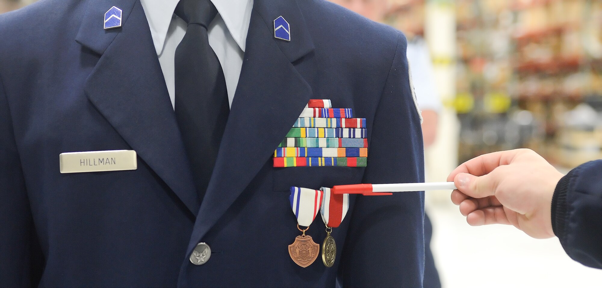 Airman 1st Class Daniel Mayfield, 436th Logistics Readiness Squadron, vehicle operations section, uses a pen to point out the mis-alignment of medals worn on the uniform of Air Force Junior Reserve Officer Training Corps Cadet Second Lieutenant Nicolas Hillman, William Penn High School, during the appearance and uniform inspection phase of the JROTC drill competition, April 20, 2013 at Dover Air Force Base, Del. The 436th Logistics Readiness Squadron, 436th Airlift Wing, Dover AFB hosted the event.  (U.S. Air Force photo/Greg L. Davis)
