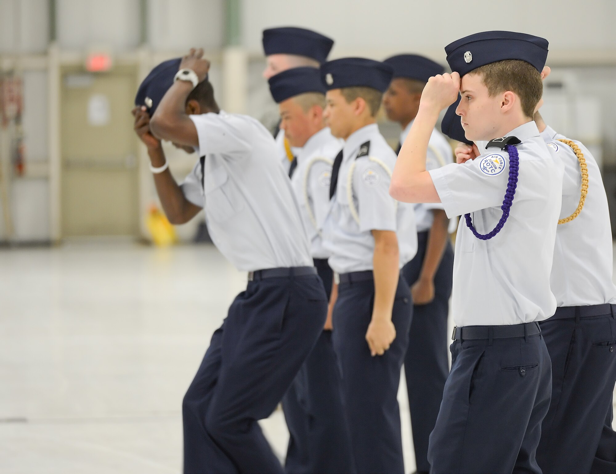 Air Force Junior Reserve Officer Training Corps cadets lighten the moment during an intensive drill competition by adjusting their flight caps as part of their routine. The cadets are competing in the 2013 Junior Reserve Officer Training Corps drill competition, April 20, 2013, hosted by the 436th Logistics Readiness Squadron, 436th Airlift Wing, Dover Air Force Base, Del. (U.S. Air Force photo/Greg L. Davis)
