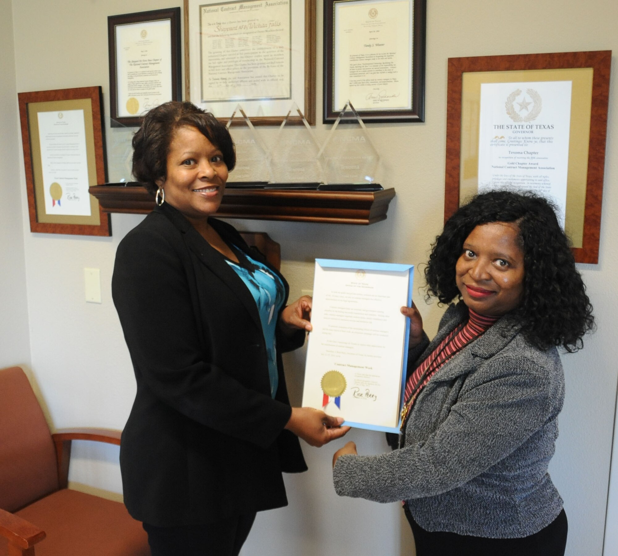 Pearlene Carr and Robin Hart, President and Vice President of the Texoma chapter respectively, hold a proclamation from Governor Rick Perry. Their chapter was awarded the Graalman award due to their work ethic and professionalism within the contracting field. (U.S. Air Force photo by Airman 1st Class Jelani Gibson) 