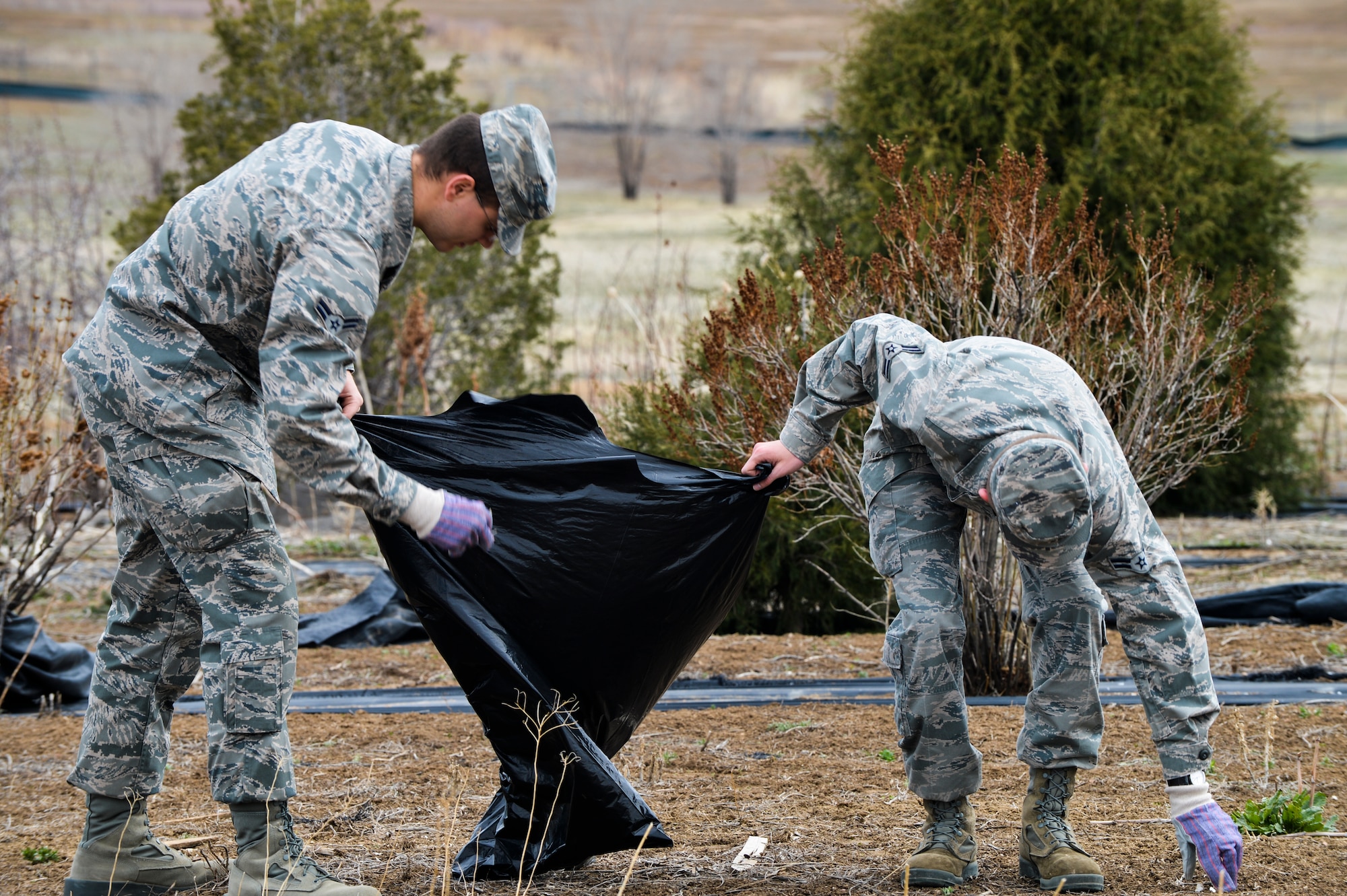 Airman 1st Class Chris Orwin, left, Detachment 45 space systems operator, and Airman 1st Class Joseph Kloc, 460th Medical Group medical technician, pick up trash April 25, 2013, on Buckley Air Force Base, Colo. during the Buckley Earth Day site cleanup. During 2013, the Air Force is highlighting water resource management programs including conservation, water quality and pollution prevention, wastewater and storm water management, and use of innovative water-saving technologies. (U.S. Air Force photo by Senior Airman Paul Labbe/Released)