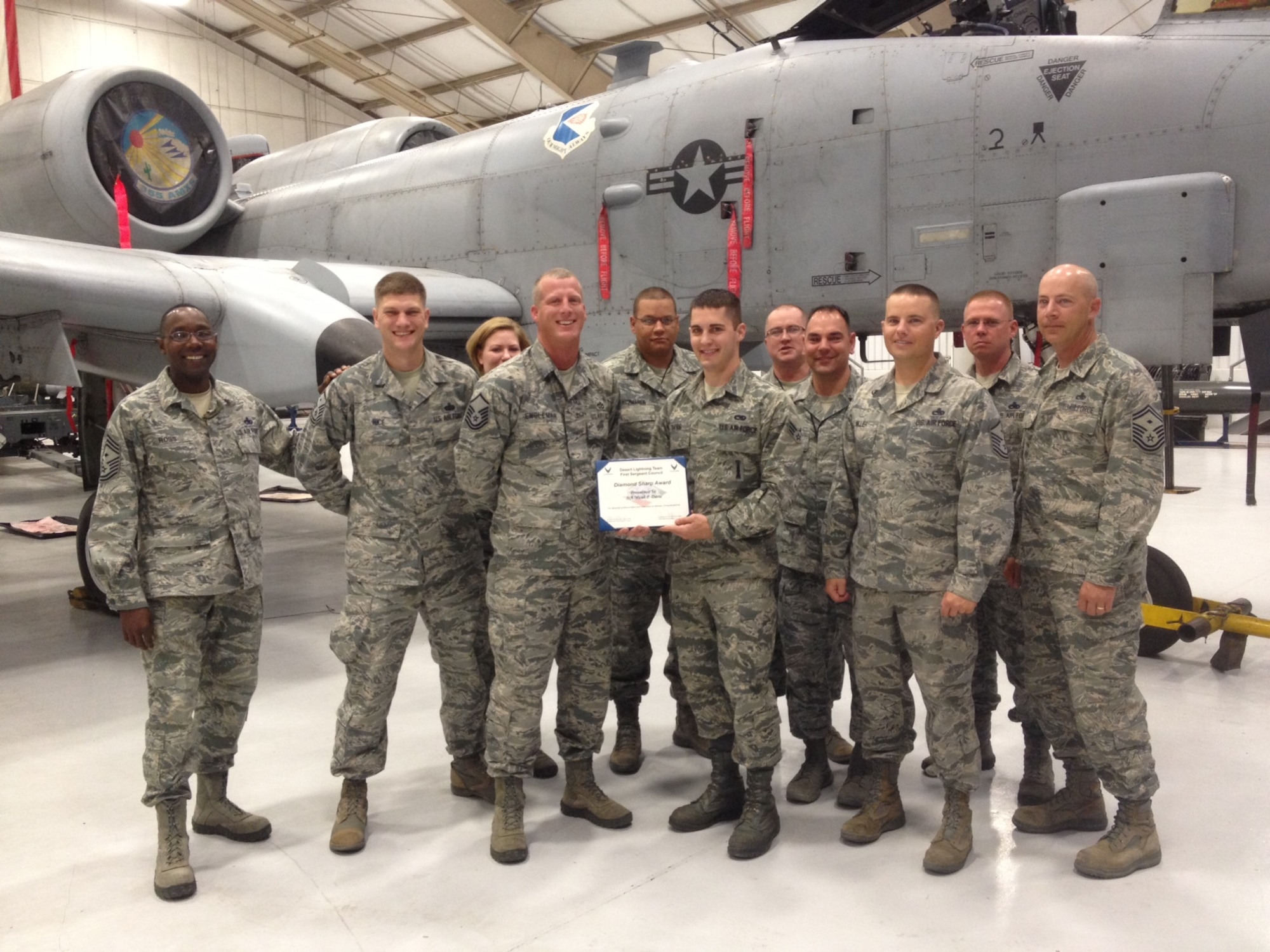 Senior Airman Micah Davis, 355th Maintenance Operations Squadron, accepts the Diamond Sharp award from Desert Lightning Team first sergeants at Davis-Monthan Air Force Base, Ariz., April 26, 2013. The Diamond Sharp award recognizes exceptional Airmen who stand out to their first sergeant. (U.S. Air Force photo by Senior Airman Timothy Moore/Released