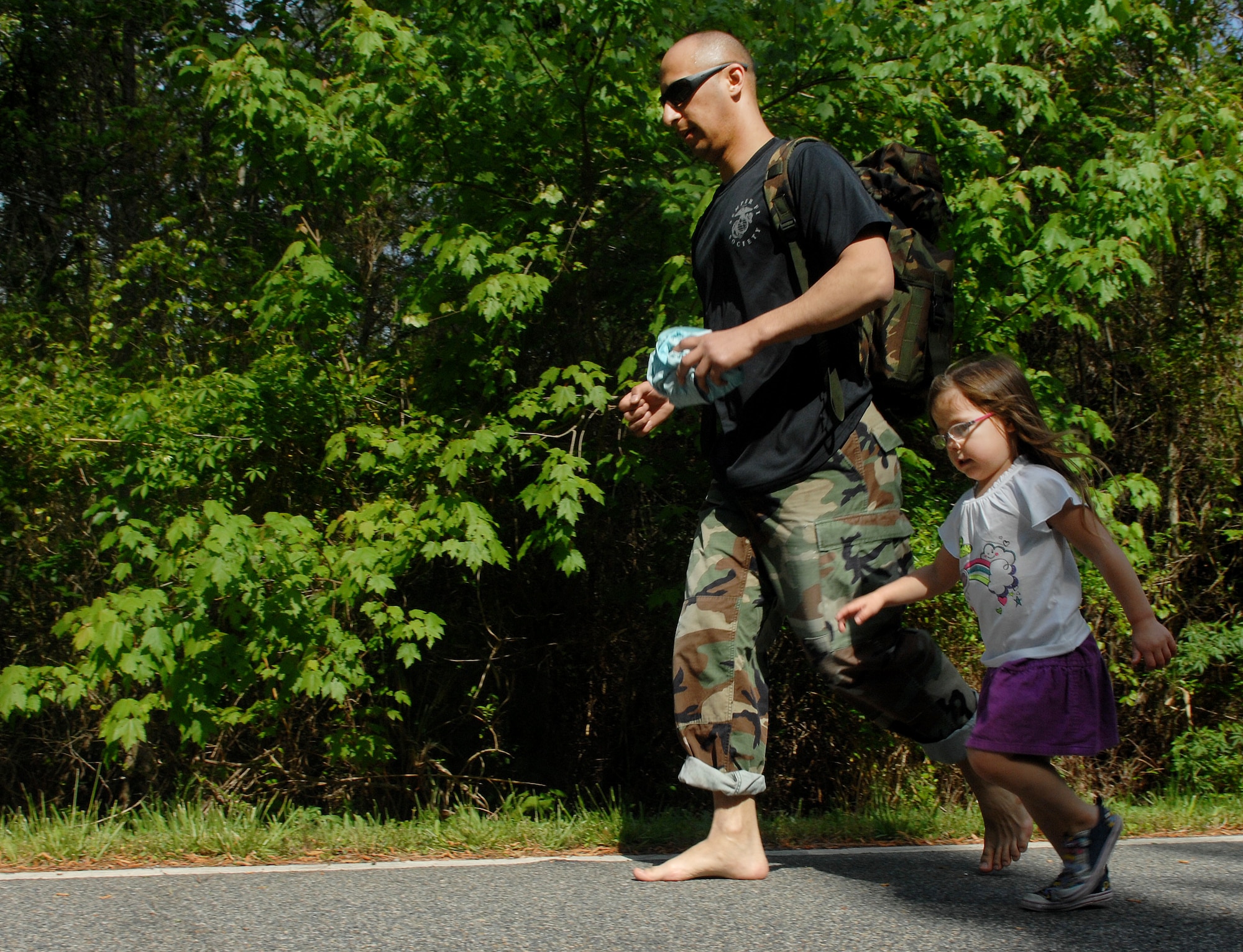A runner and his daughter participate in the 1-mile portion of the Bataan Death March memorial walk at Chesapeake, Va., April 27, 2013. In addition to the 16.6-mile walk, participants could choose to walk or run a shorter five or one-mile distance to honor veterans of the original Bataan Death March. (U.S. Air Force photo by Airman 1st Class Austin Harvill/Released)
