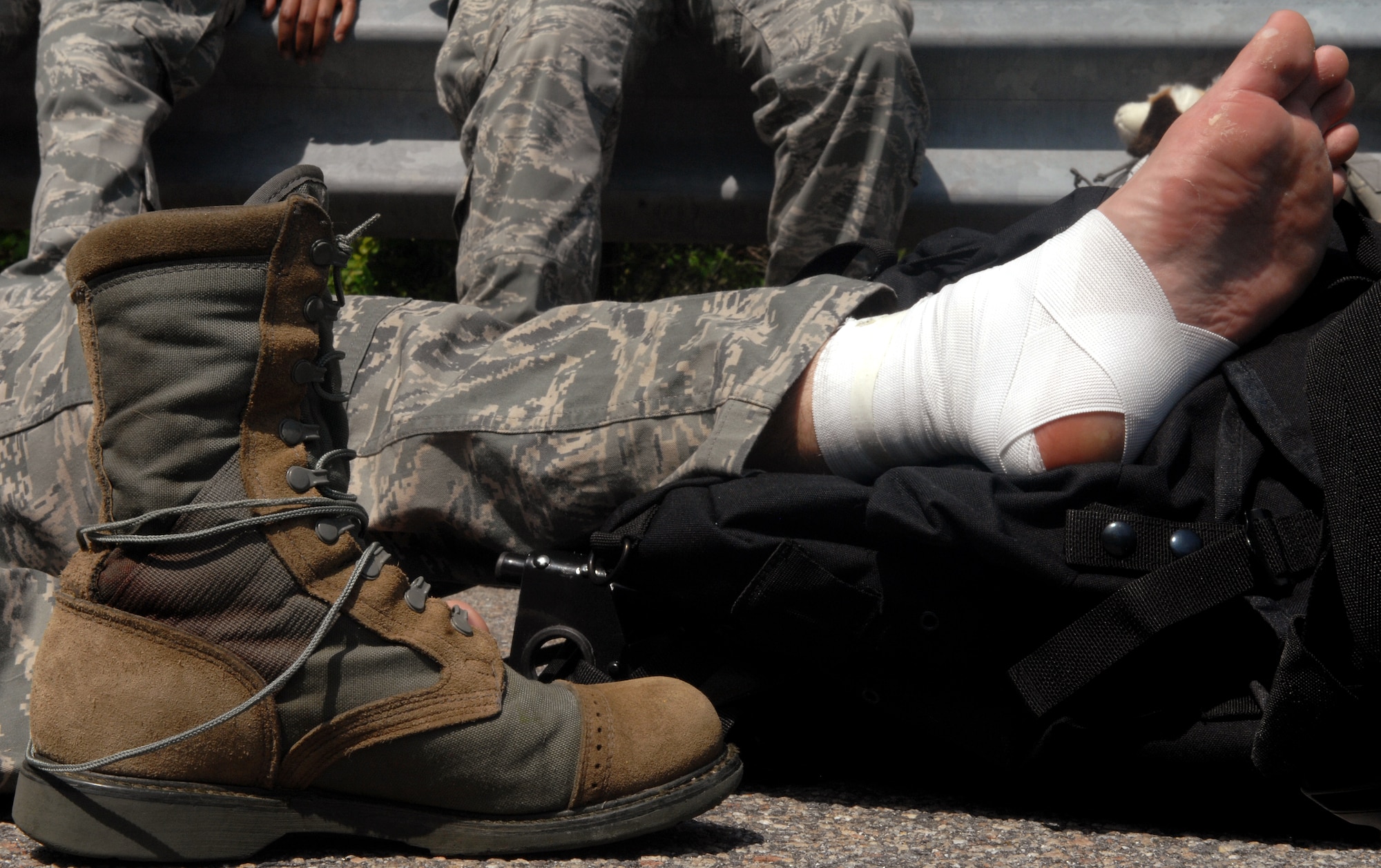 An Airman displays his newly bandaged foot after discovering his heels had been bleeding during the 16.6-mile Bataan Death March memorial walk at Chesapeake, Va., April 27, 2013. A number of walkers sustained minor injuries like sprained ankles, blisters and dehydration. The pain felt by participants was intentional so they could feel a fraction of the abuse veterans of the original Bataan Death March endured. (U.S. Air Force photo by Senior Airman Teresa Aber/Released)