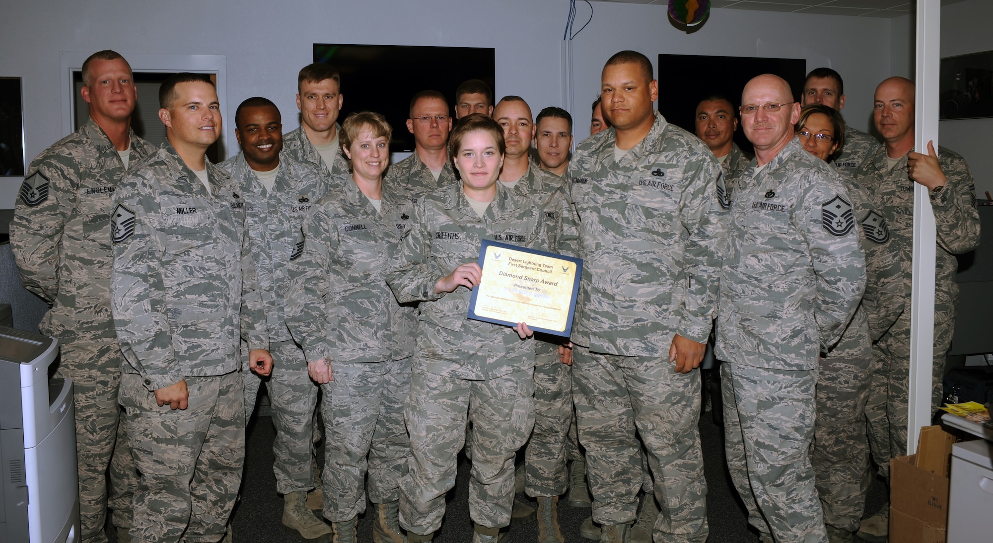 Airman 1st Class Christine Griffiths, 355th Fighter Wing Public Affairs, accepts the Diamond Sharp award from Desert Lightning Team first sergeants at Davis-Monthan Air Force Base, Ariz., April 22, 2013. The Diamond Sharp award recognizes exceptional Airmen who stand out to their first sergeant. (U.S. Air Force photo by Senior Airman Timothy Moore/Released