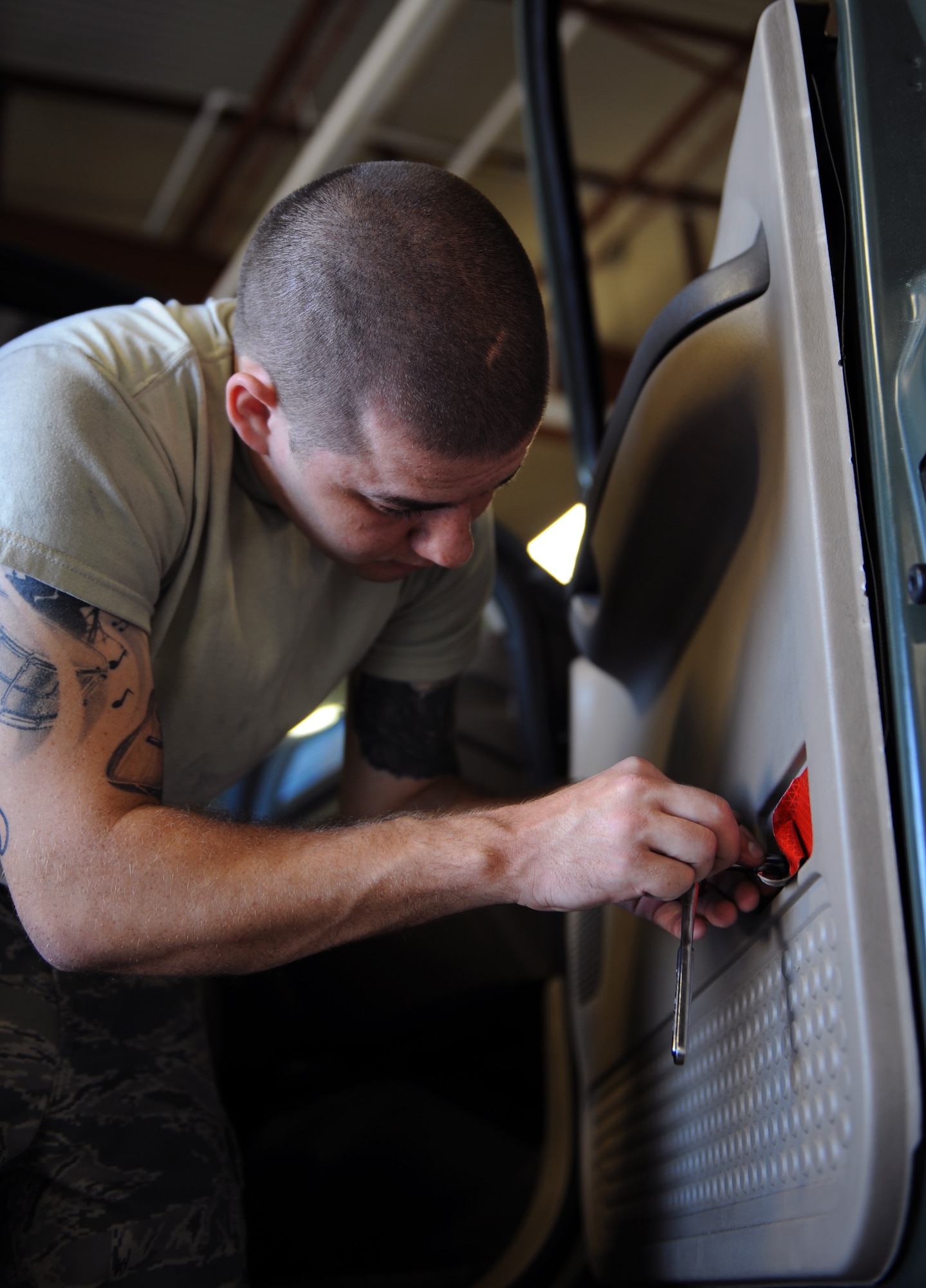 Airman 1st Class Troy Hammond, 2nd Logistics Readiness Squadron Vehicle Maintenance, unscrews a bolt from a door panel at the Allied Trades section on Barksdale Air Force Base, La., April 30, 2013. The Allied Trades section conducts frame and body repairs to include upholstery, paint, glass and tires. (U.S. Air Force photo/Airman 1st Class Benjamin Gonsier)
