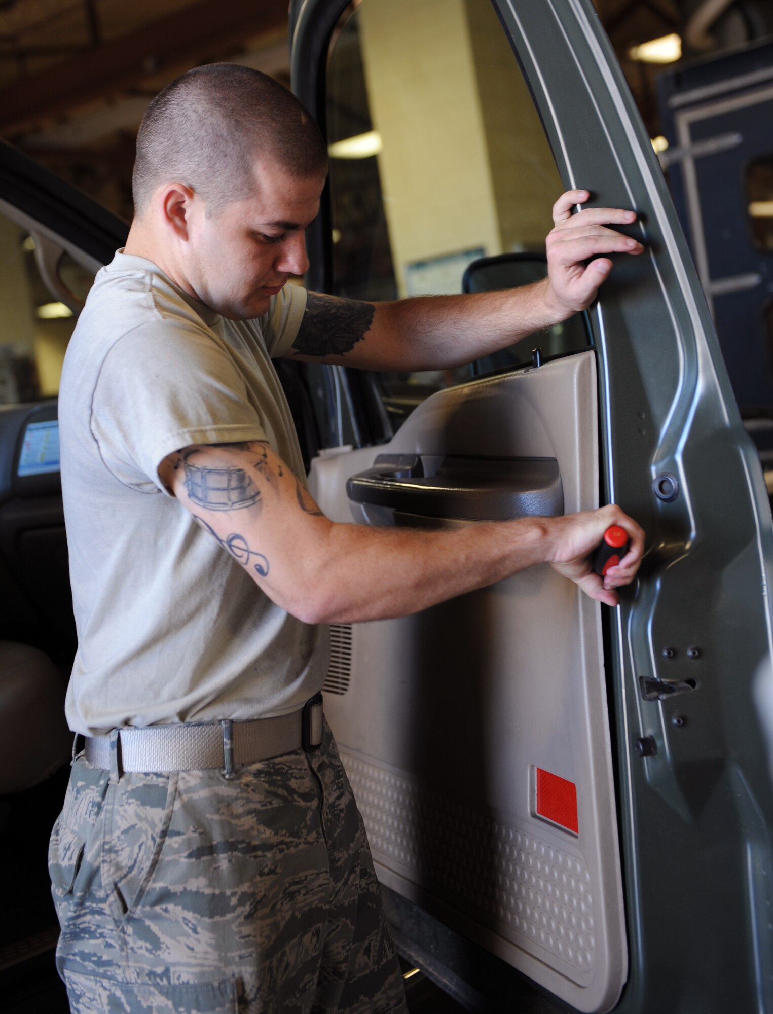 Airman 1st Class Troy Hammond, 2nd Logistics Readiness Squadron Vehicle Maintenance, disconnects a door panel from a vehicle at the Allied Trades section on Barksdale Air Force Base, La., April 30, 2013. The Allied Trades section maintains vehicle frames and glass of more than 700 government-owned vehicles on Barksdale as well as gives them new paint jobs. (U.S. Air Force photo/Airman 1st Class Benjamin Gonsier)
