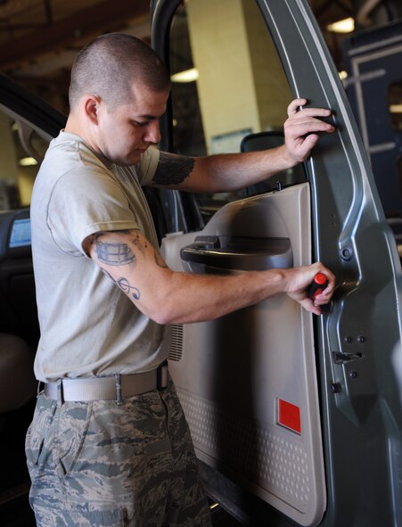 Airman 1st Class Troy Hammond, 2nd Logistics Readiness Squadron Vehicle Maintenance, disconnects a door panel from a vehicle at the Allied Trades section on Barksdale Air Force Base, La., April 30, 2013. The Allied Trades section maintains vehicle frames and glass of more than 700 government-owned vehicles on Barksdale as well as gives them new paint jobs. (U.S. Air Force photo/Airman 1st Class Benjamin Gonsier)