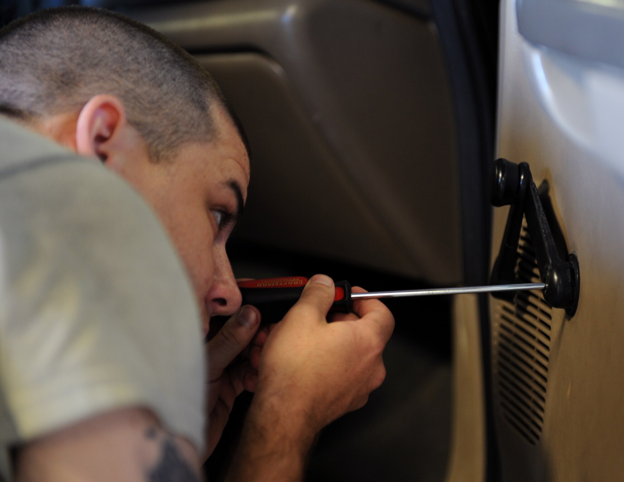 Airman 1st Class Troy Hammond, 2nd Logistics Readiness Squadron Vehicle Maintenance, removes a door handle from a vehicle at the Allied Trades section on Barksdale Air Force Base, La., April 30, 2013. Hammond removed parts of the door panel in order to fix the door lock. (U.S. Air Force photo/Airman 1st Class Benjamin Gonsier)
