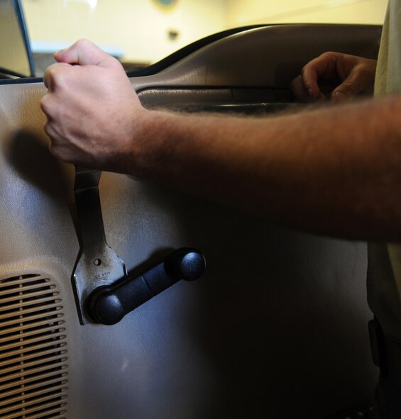 Airman 1st Class Troy Hammond, 2nd Logistics Readiness Squadron Vehicle Maintenance, removes a door handle from a vehicle at the Allied Trades section on Barksdale Air Force Base, La., April 30, 2013. The Allied Trades section maintains vehicle frames and glass of more than 700 government-owned vehicles on Barksdale as well as gives them new paint jobs. (U.S. Air Force photo/Airman 1st Class Benjamin Gonsier)