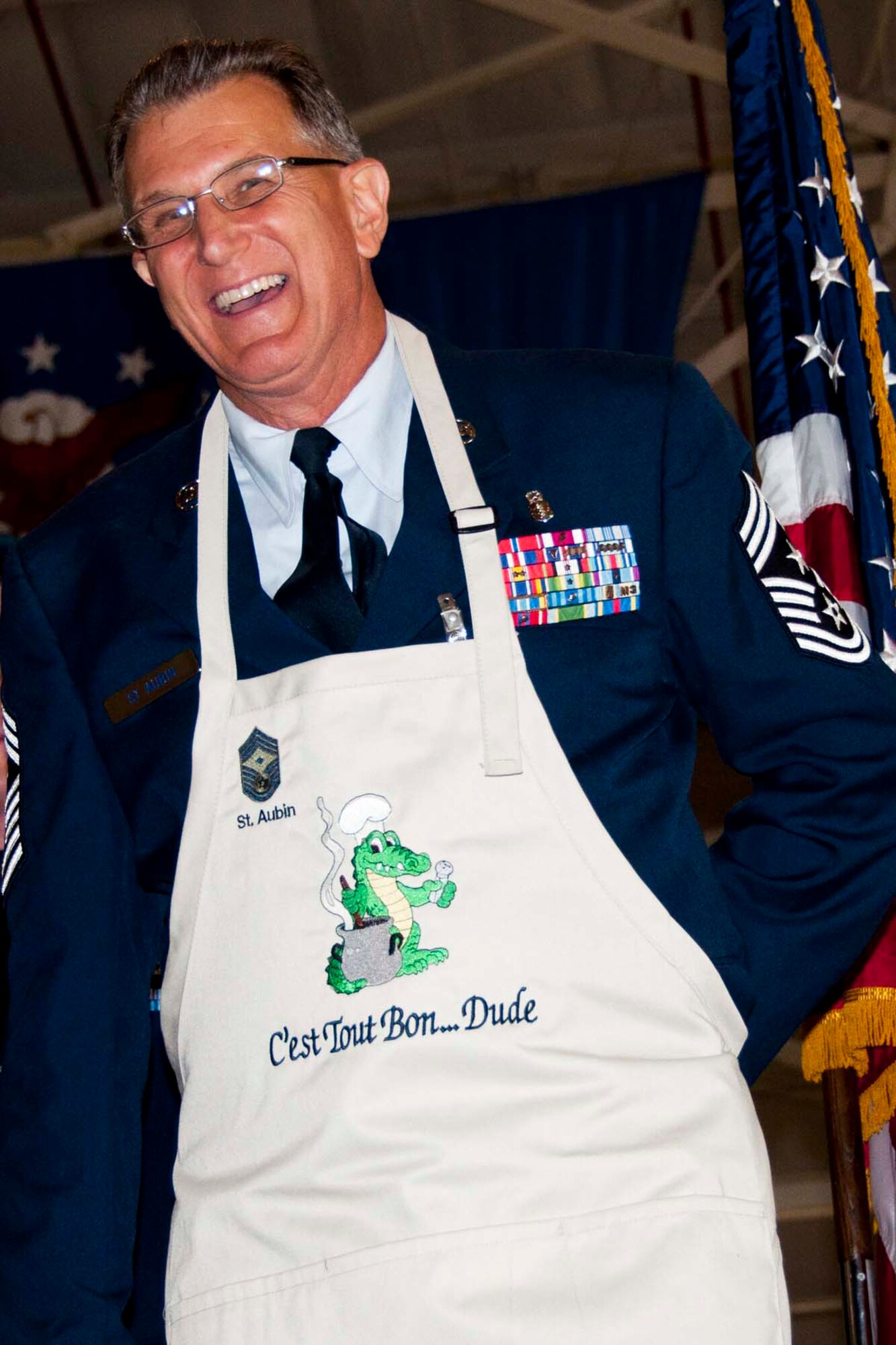 U.S. Air Force Chief Master Sgt. Keith St. Aubin, the 307th Bomb Wing’s Command Chief Master Sgt., laughs as he tries on an apron given to him as a gift during his retirement ceremony at Barksdale Air Force Base, La., April 27, 2013.  St. Aubin, an avid Cajun cook, served in both the U.S. Army and the U.S. Air Force.  His career spanned more than thirty years. (U.S. Air Force photo by Tech. Sgt. Ted Daigle/Released)