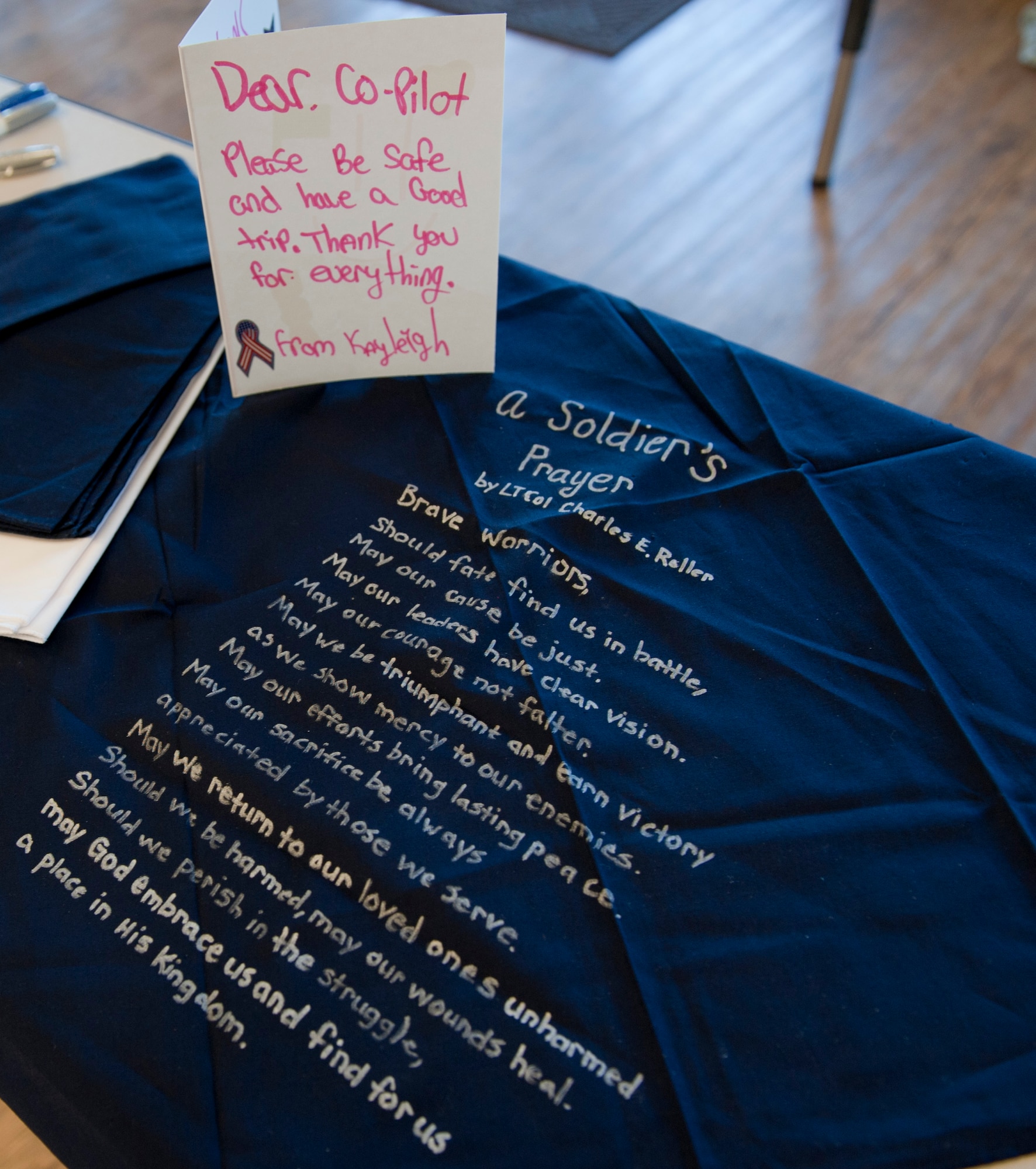 A bandana with the Soldier’s Prayer written on it along with a thank you card to a co-pilot, sits on a table at the Children in Crisis Clubhouse in Fort Walton Beach, Fla., April 23, 2013. A group of 15 children baked cookies and brownies, made thank you cards and bandanas with the Soldier’s Prayer on them for delivery to troops. (U.S. Air Force photo by Senior Airman Krystal M. Garrett) 