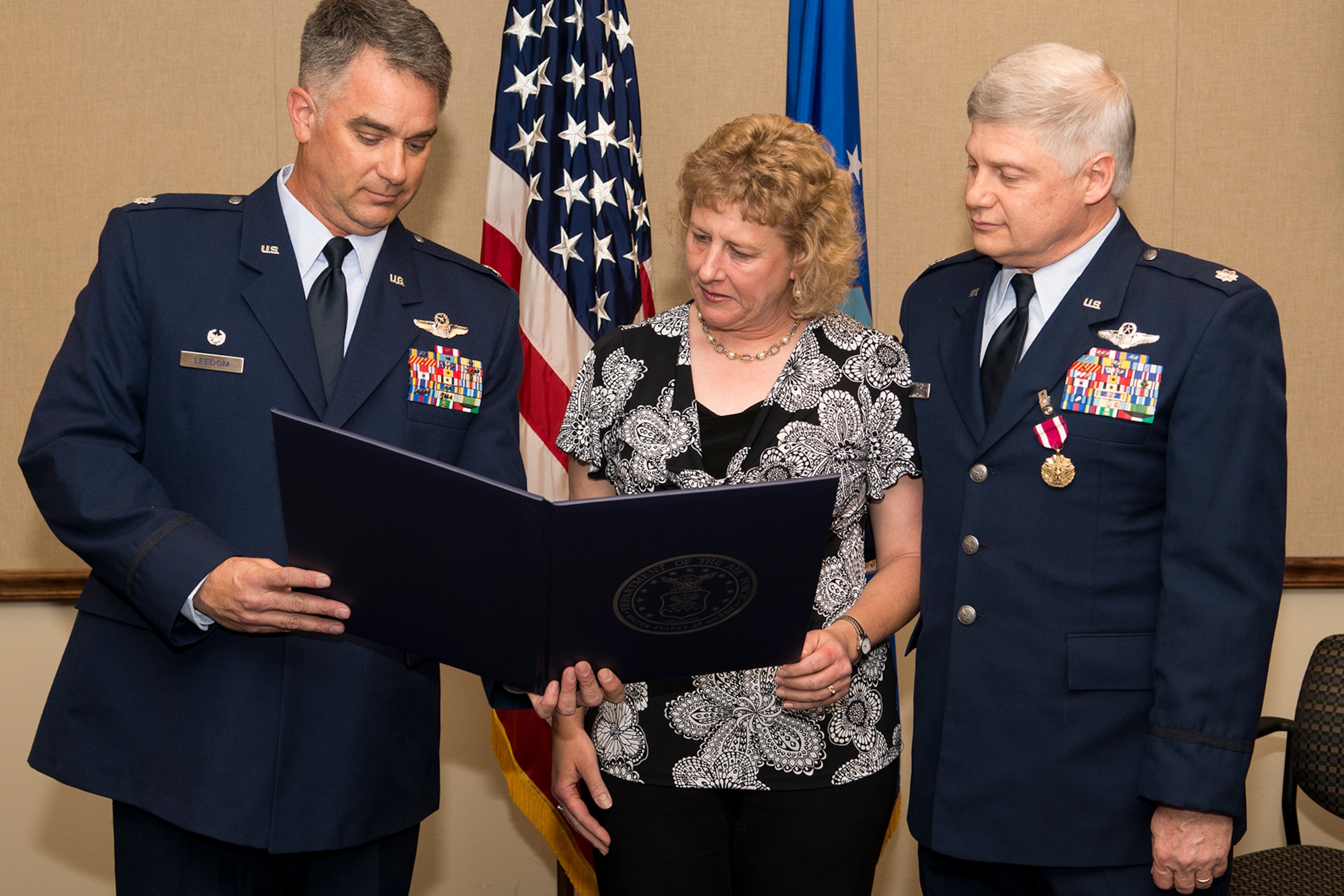 Jennifer Holt reads the Spouse Certificate during the retirement ceremony for her husband, U.S. Air Force Lt. Col. Richard Holt (right), April 26, 2013, Barksdale Air Force Base, La. Holt is a B-52H Stratofortress Electronic Warfare Officer assigned to the 93rd Bomb Squadron, 307th Bomb Wing. (U.S. Air Force photo by Master Sgt. Greg Steele/Released)