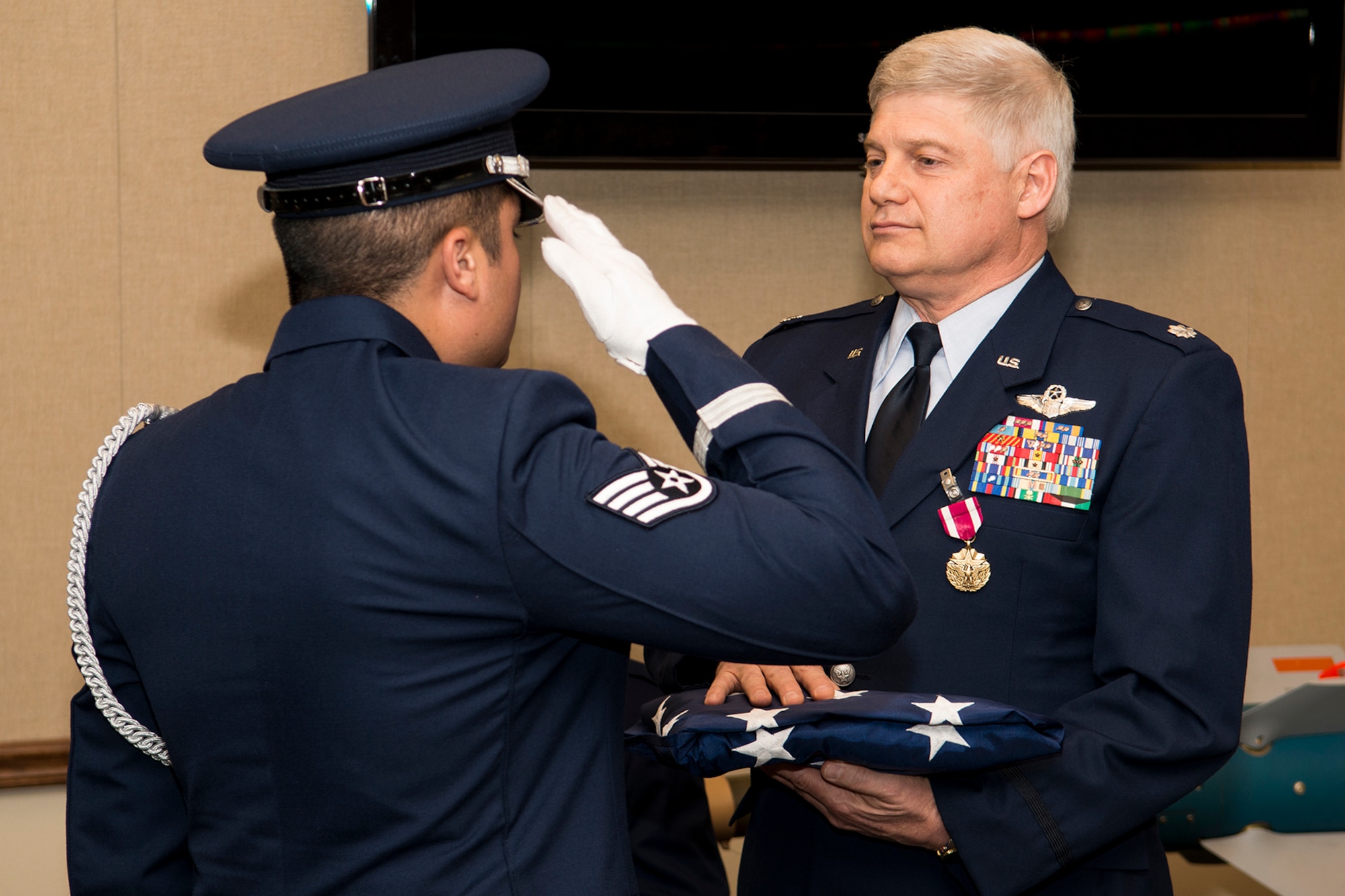 U.S. Air Force Lt. Col. Richard Holt holds an American Flag following a flag folding ceremony as part of his retirement ceremony, April 26, 2013, Barksdale Air Force Base, La. Holt is retiring after serving 28 years in the military as an Electronic Warfare Officer in the B-52H Stratofortress. (U.S. Air Force photo by Master Sgt. Greg Steele/Released)