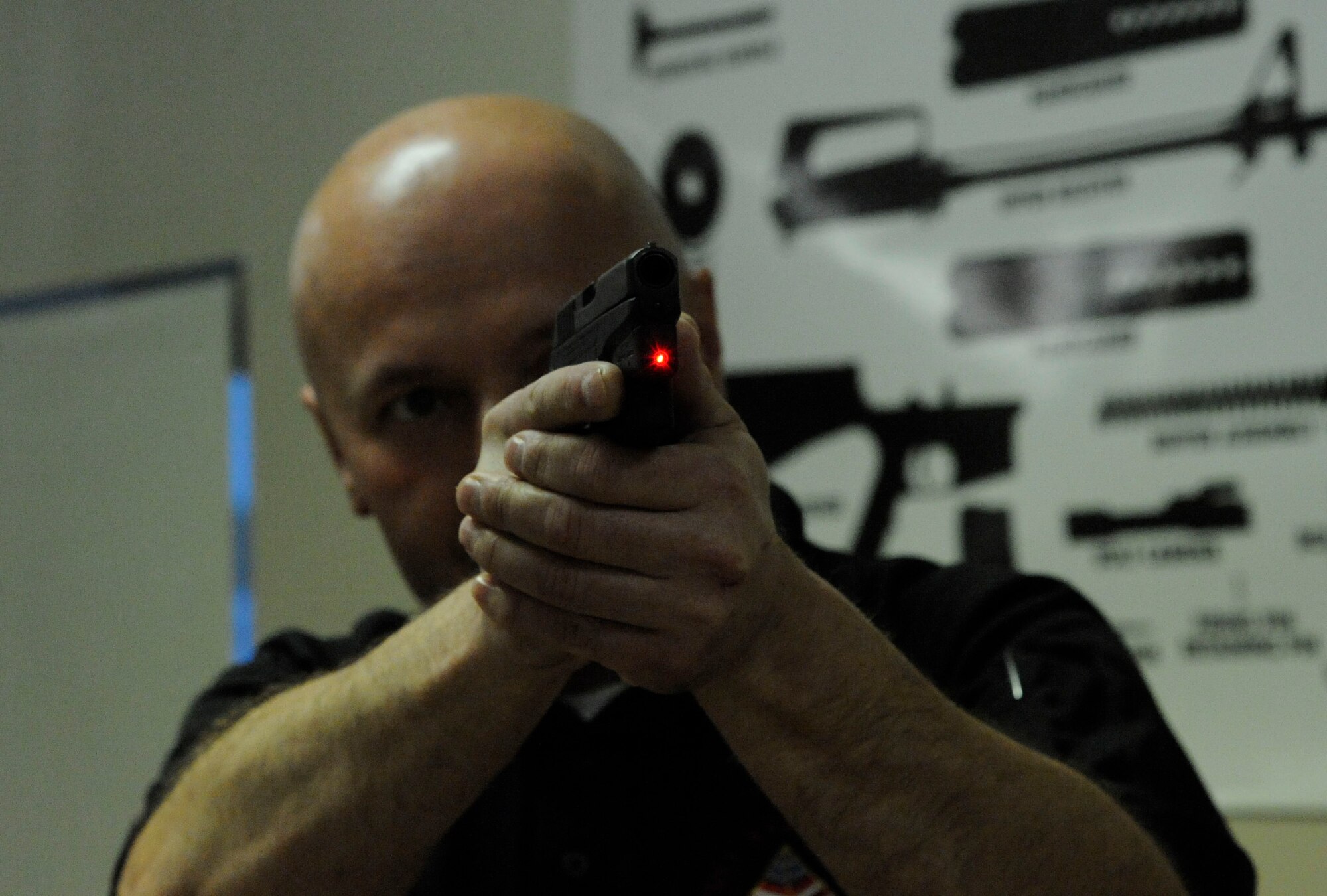 Peter Desjardin, Air Force Global Strike Command, aims a laser sight during a Women's Introduction to Firearms class on Barksdale Air Force Base, La., April 26, 2013. The class taught women about various firearms ranging from handguns, shotguns and rifles. (U.S. Air Force photo/Airman 1st Class Andrew Moua)