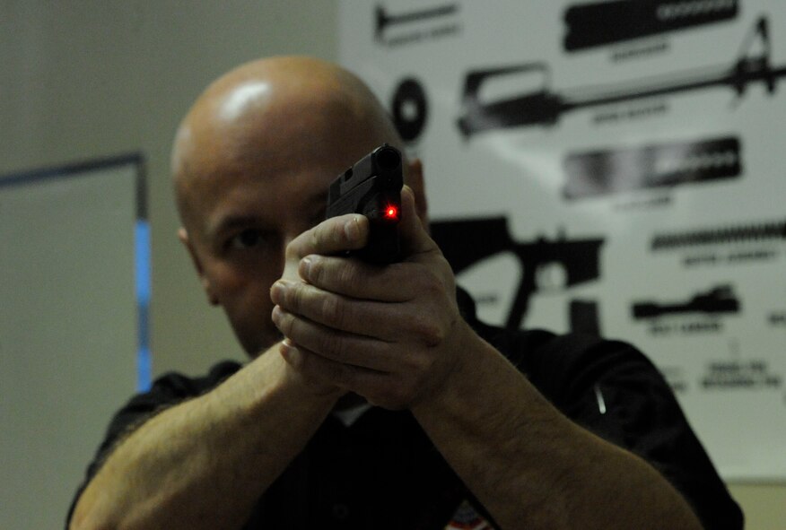 Peter Desjardin, Air Force Global Strike Command, aims a laser sight during a Women's Introduction to Firearms class on Barksdale Air Force Base, La., April 26, 2013. The class taught women about various firearms ranging from handguns, shotguns and rifles. (U.S. Air Force photo/Airman 1st Class Andrew Moua)